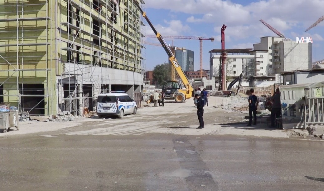 Battalgazi’deki şantiye alanında çalışan bir işçi, kepçe ile duvar arasında